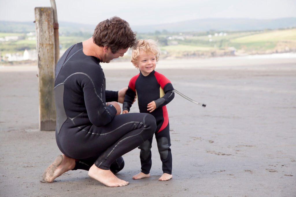 father-and-son-on-beach-wearing-wet-suits-2026-03-11-01-00-13-utc