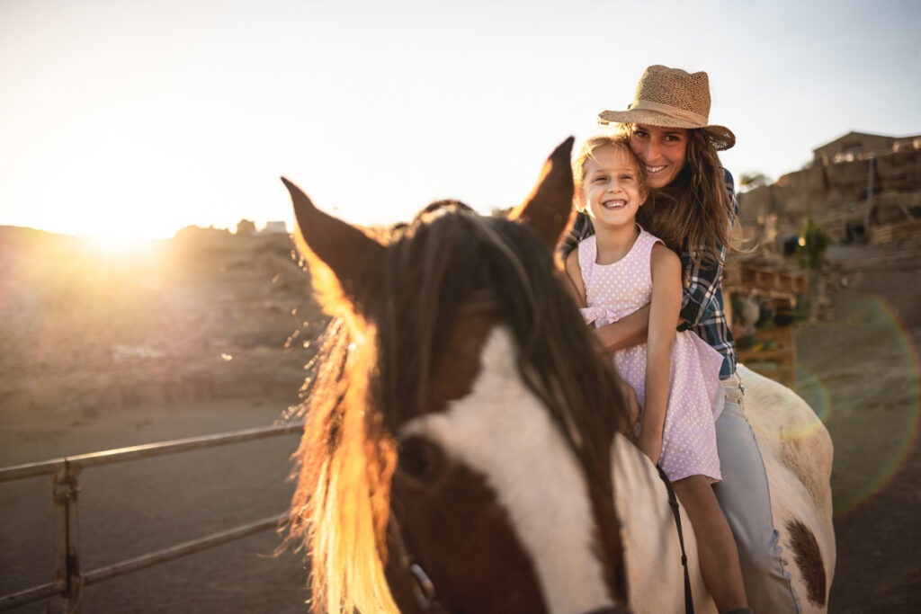 happy-mother-and-daughter-riding-a-horse-at-sunset-2026-01-08-05-35-48-utc