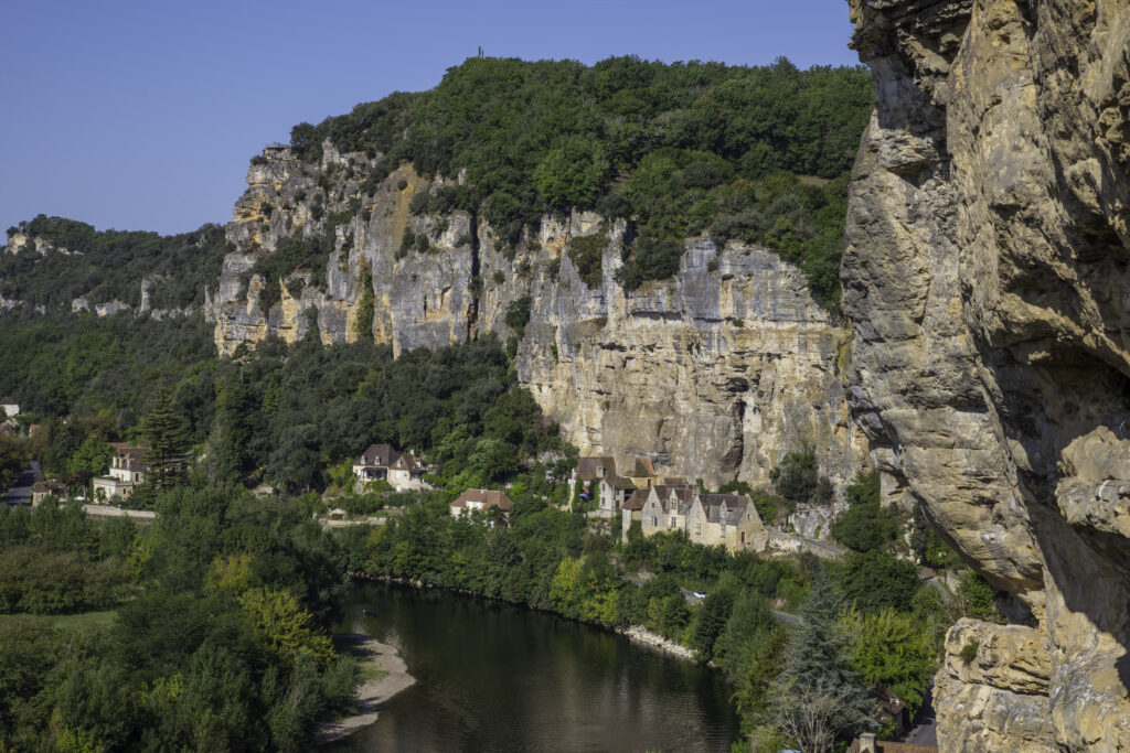 the rocks in the dordogne area with the river and old houses