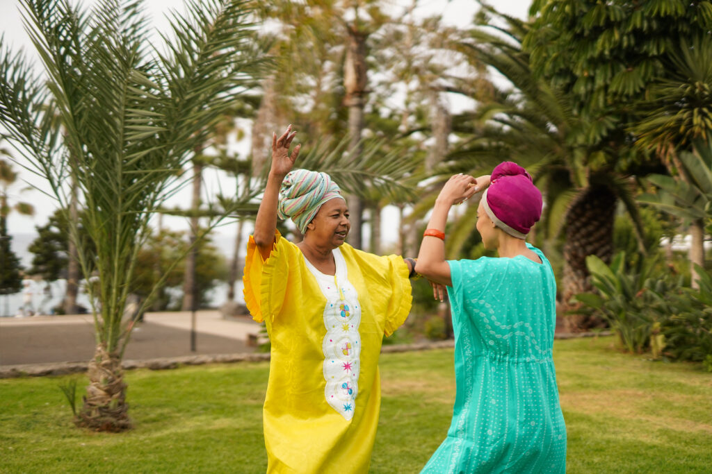 Happy african mother and daughter dancing together outdoor – Fam